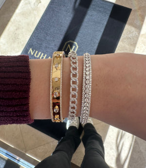 Female Model Wearing Bezel-Set Diamond Shapes Bangle Bracelet - 18K gold weighing 22.57 grams - 142 round diamonds weighing 0.86 carats - 2 marquise-shaped diamonds weighing 0.23 carats - 3 pear-shaped diamonds weighing 0.32 carats