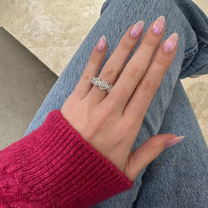 Female model wearing Halo Diamond Eternity Band -18k gold, 7.95 grams, 153 round shared prong-set brilliant diamonds 1.09 carats. - 9 round brilliant diamonds 4.12 carats.