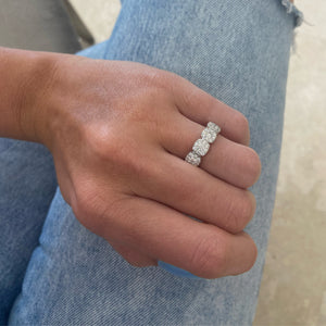 Female model wearing Diamond cushion-style halo eternity ring -18K gold weighing 4.18 grams -11 round diamonds totaling 0.98 carats -88 round pave-set diamonds totaling 1.30 carats