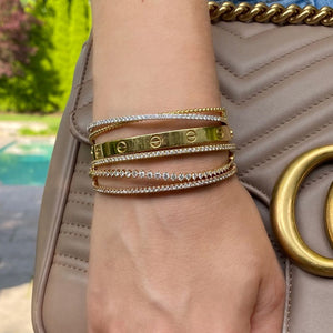 Female Model Wearing Prong-Set Diamond Wave Bangle - 14K gold weighing 8.05 grams - 27 round diamonds totaling 1.09 carats