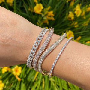 Female model wearing Diamond Wavy Bangle - 18K gold weighing 13.32 grams - 229 round diamonds totaling 2.91 carats