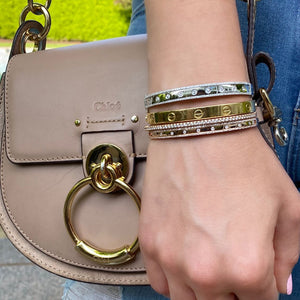 Female model wearing Bezel-Set & Pave Diamond Wide Bangle Bracelet -14K gold weighing 14.45 grams -9 round bezel set diamonds totaling 0.52 carats -146 round pave set diamonds totaling 0.44 carats