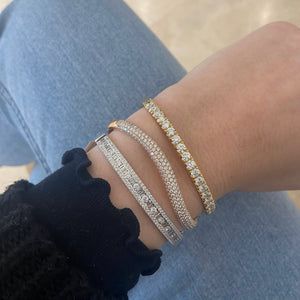 Female model wearing Round & Baguette Diamond Bangle - 14K gold weighing 13.12 grams - 143 round diamonds totaling 1.92 carats - 24 straight baguettes weighing 0.73 carats