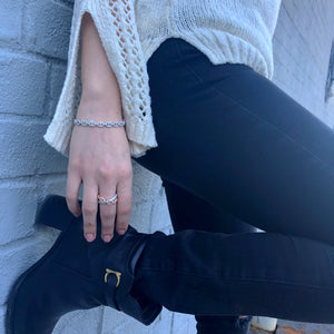 Female model wearing Diamond Tri-Link Bangle Bracelet -18K gold weighing 13.08 grams -140 round diamonds weighing .85 carats