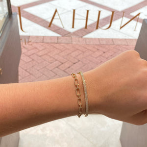 Female model wearing Pave Diamond Triple Row Bangle - 14K gold weighing 6.94 grams - 212 round diamonds totaling 0.52 carats