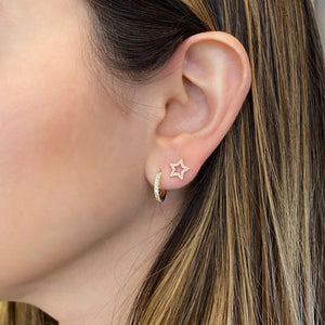 Female model wearing Diamond Open Star Stud Earrings - 14K gold weighing 1.22 grams - 50 round diamonds totaling 0.12 carats