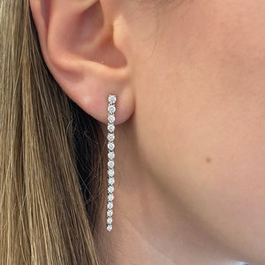 Female model wearing Diamond Drip Earrings - 18K gold weighing 4.07 grams - 4 round diamonds totaling 0.33 carats - 28 round diamonds totaling 1.27 carats