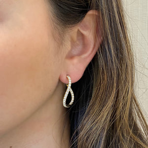 Female Model Wearing Small Diamond Twist Hoop Earrings -18K gold weighing 6.25 grams  -58 round diamonds totaling 1.78 carats