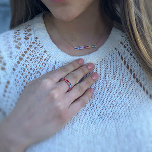 Female model wearing Rainbow baguette eternity ring -14k gold weighing 4.05 grams -30 multi-color stones weighing 3.39 carats