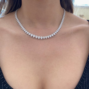 Female Model Wearing Diamond Teardrops Tennis Necklace  - 18K gold weighing 35.84 grams  - 8.31 carats of pear-shaped diamonds  - 972 round diamonds totaling 4.67 carats