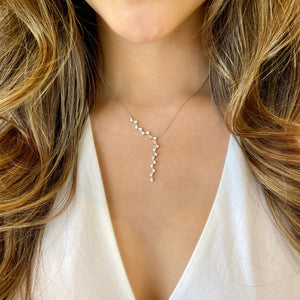 Female Model Wearing Diamond 'V' Lariat Necklace  -14k gold weighing 3.18 grams  -88 round pave-set diamonds totaling 0.20 carats   - 14K gold weighing 4.04 grams  - 36 round diamonds totaling 1.01 carats