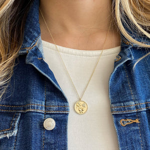 Female Model Wearing Diamond Luck, Love, and Happiness Disc Pendant  - 14K gold weighing 5.18 grams  - 95 round diamonds totaling 0.21 carats  - 14K gold weighing 4.71 grams  - 83 round diamonds totaling 0.18 carats