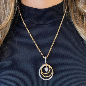 Female model wearing Diamond & Tri-Color Gold Circle of Life Pendant - 18K  tricolor gold weighing 9.75 grams - 136 round diamonds totaling 1.60 carats - 14k tricolor chain weighing 4.1 grams.