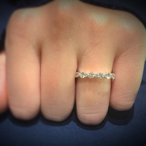 Female Model Wearing Single Prong Diamond Eternity Ring -18k gold weighing 2.72 grams -14 round bezel-set diamonds weighing 1.81 carats -14 round bezel-set diamonds weighing .14 carats