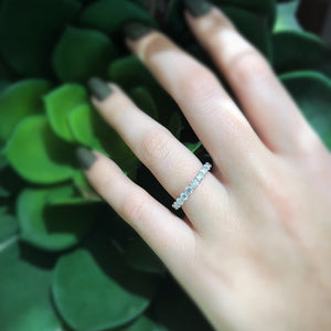 Female Model Wearing Shared Prong-Set Diamond Eternity Band -18k gold weighing 1.94 grams -21 round diamonds weighing 2.05 grams