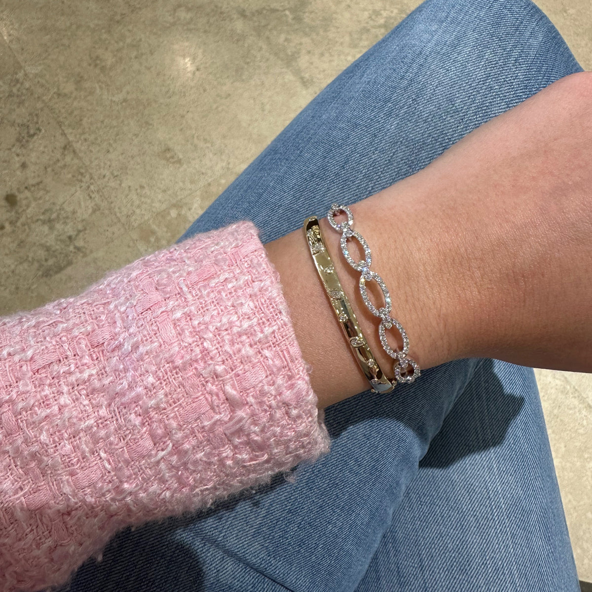 Female model wearing Round & Pear-shaped diamond bangle bracelet 
- 14K gold weighing 13.64 grams
- 6 round diamonds weighing 0.09 carats
- 3 pear-shaped diamonds weighing 0.18 carats