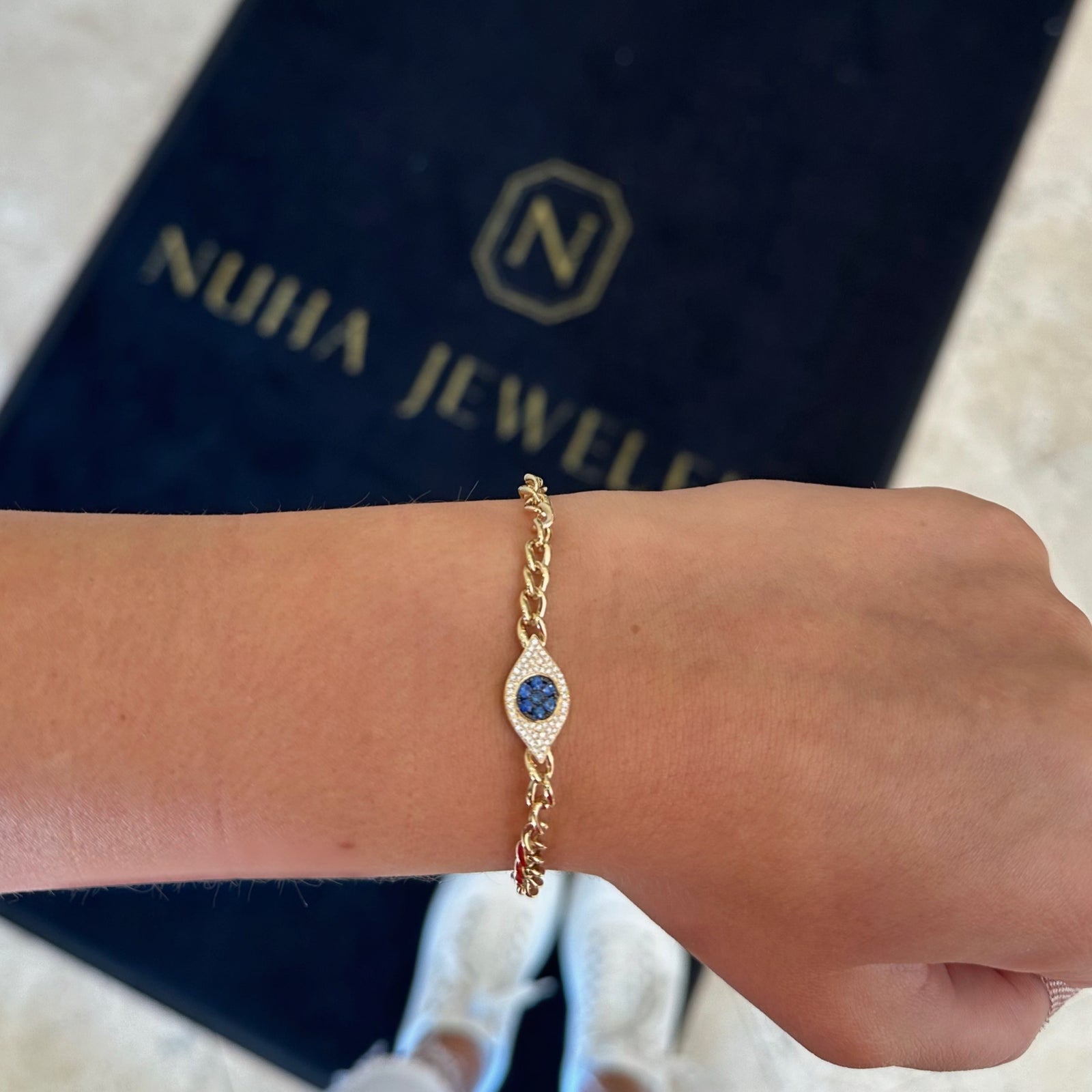 Sapphire & Diamond Evil Eye Curb Chain Bracelet -14K gold weighing 7.35 grams -52 round diamonds totaling 0.14 carats -7 sapphires totaling 0.15 carats