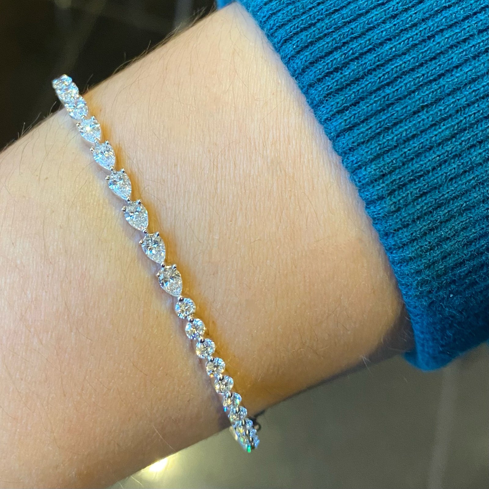 Round & Pear-Shaped Diamond Bangle Bracelet - 18K gold weighing 11.06 grams  - 12 round diamonds weighing 0.68 carats  - 9 pear-shaped diamonds weighing 0.96 carats