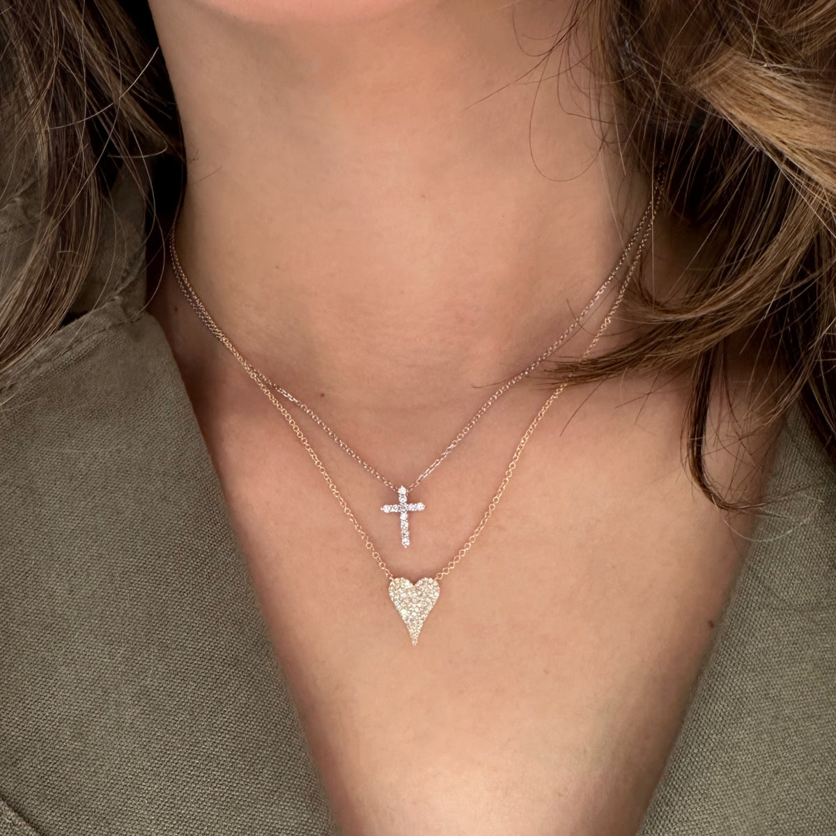 Woman wearing Diamond Small Cross Pendant - 14K yellow gold weighing 2.03 grams -11 round diamonds totaling 0.14 carats