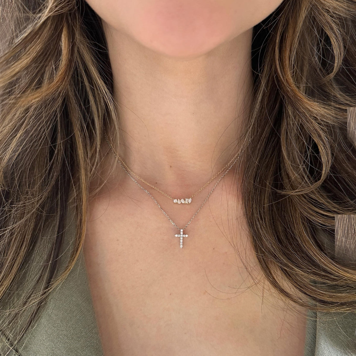 Female model wearing Diamond Small Cross Pendant - 14K yellow gold weighing 2.03 grams -11 round diamonds totaling 0.14 carats