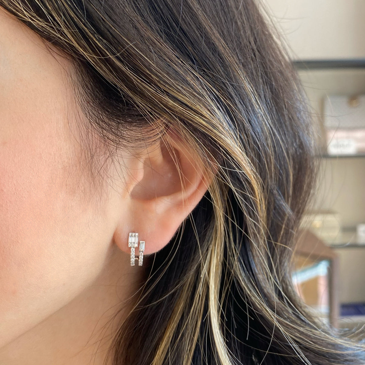 Female model wearing diamond double huggie earrings with diamond baguettes - 18K gold weighing 2.31 grams
- 8 straight baguettes weighing 0.28 carats
- 34 round diamonds weighing 0.21 carats