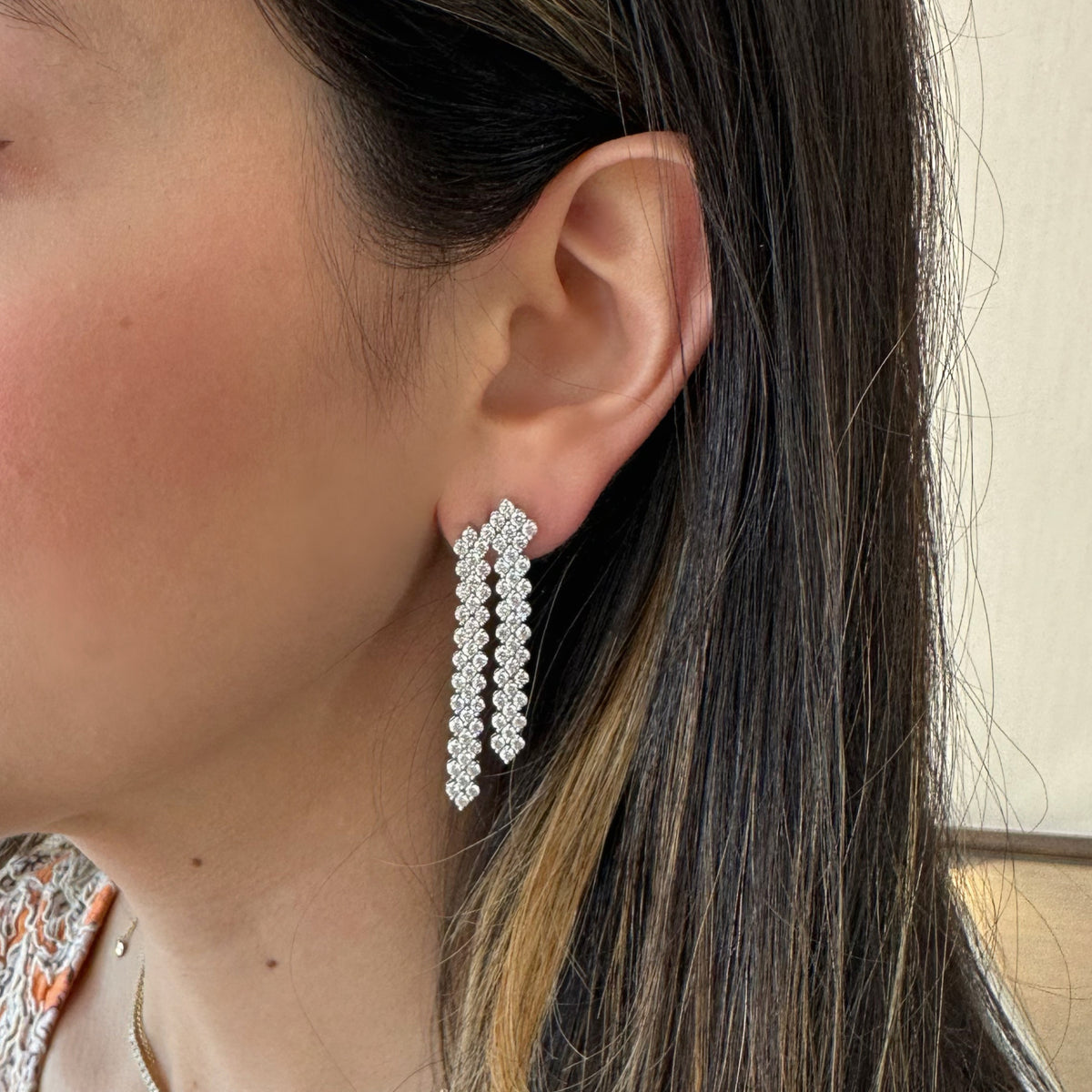 Female model wearing Diamond Waterfall Earrings - 14K gold weighing 12.27 grams - 146 round diamonds weighing 5.84 carats
