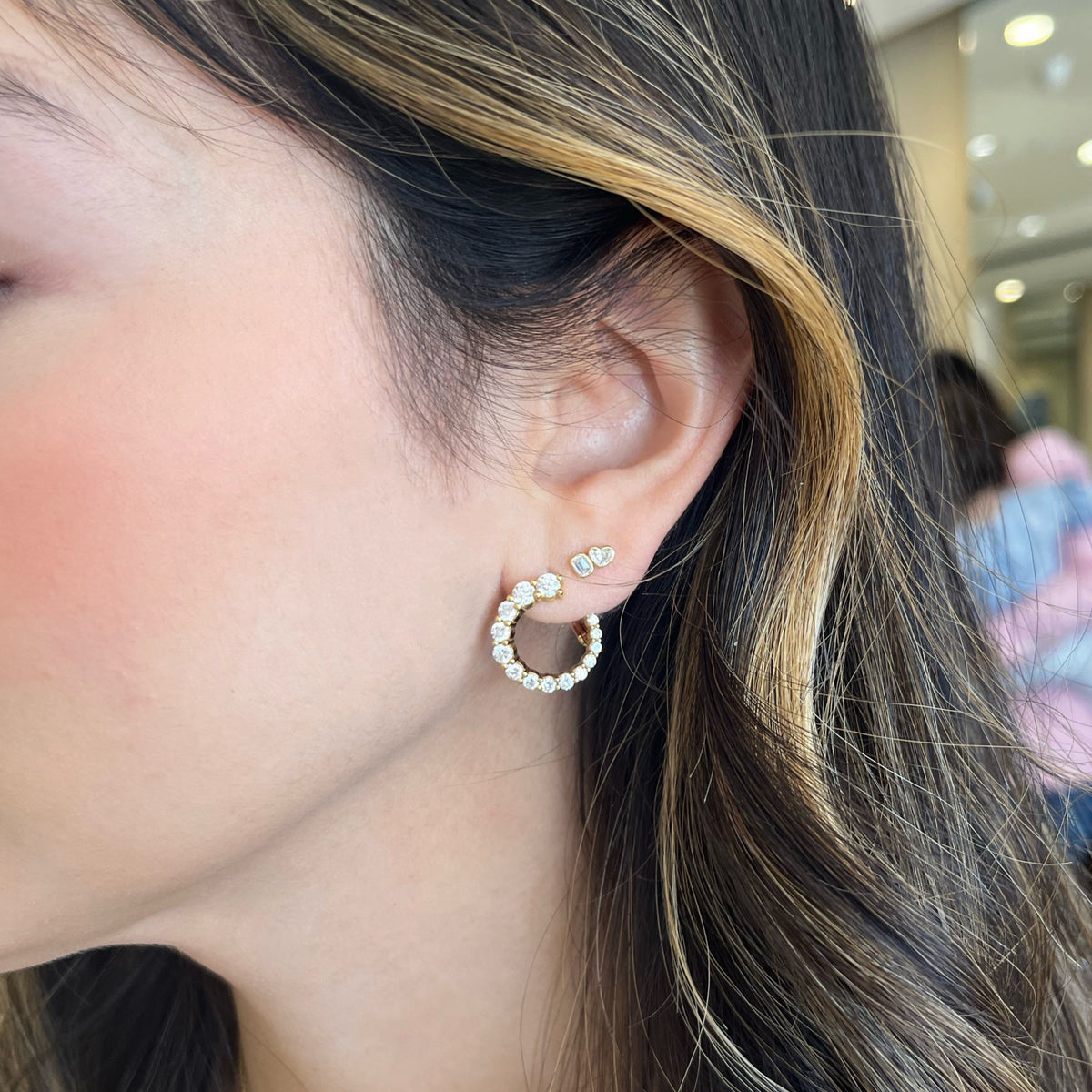 Female Model Wearing  Heart & Emerald-Cut Diamond Duet Stud Earrings - 14K gold weighing 0.98 grams - 4 mixed shape diamonds weighing 0.40 carats