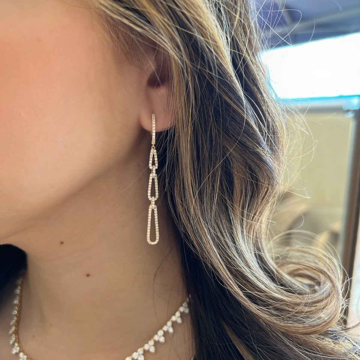 Female Model Wearing Diamond Triple Teardrop Dangle Earrings - 18K gold weighing 6.20 grams - 186 round diamonds weighing 1.45 carats