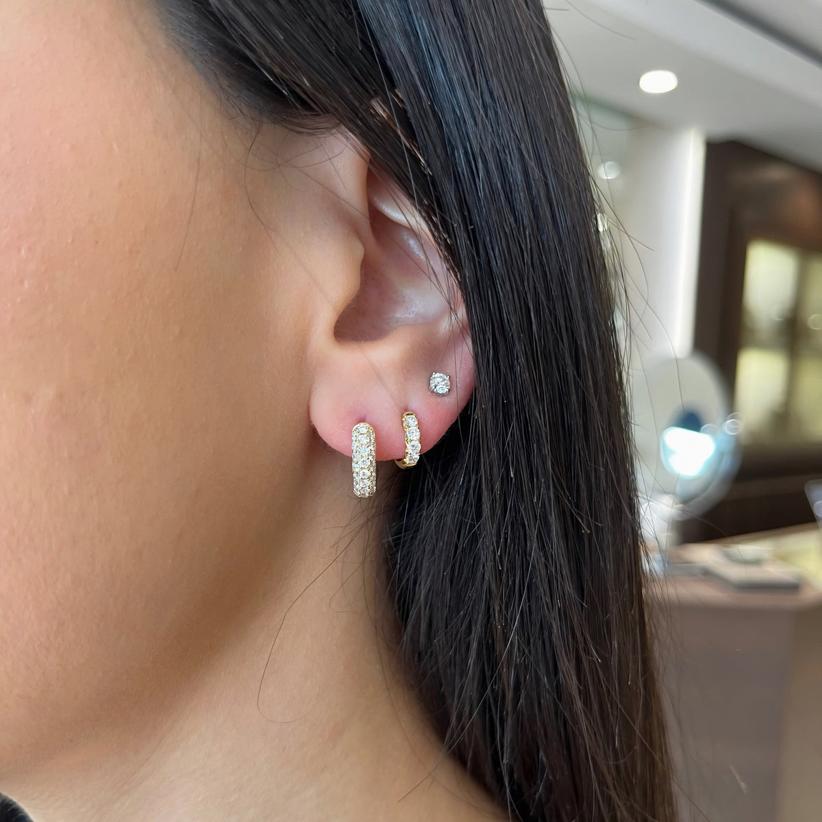 Female Model Wearing Pavé Diamond Rounded Huggie Earrings - 14K gold weighing 3.47 grams - 50 round diamonds weighing 0.93 carats