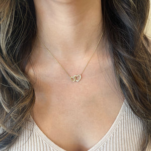 Female Model Wearing Diamond & Pleated Gold Interlocking Hearts Pendant Necklace - 14K gold weighing 2.66 grams - 55 round diamonds weighing 0.14 carats