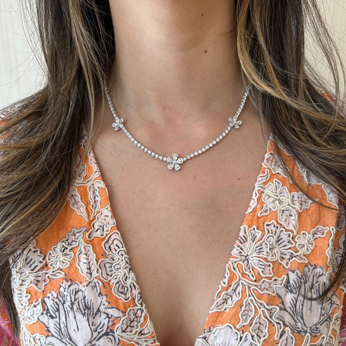 Female Model Wearing Diamond Flower Tennis Necklace - 18K gold weighing 20.02 grams - 15 pear-shaped diamonds weighing 1.55 carats - 115 round diamonds weighing 5.76 carats - 48 round diamonds weighing 3.50 carats