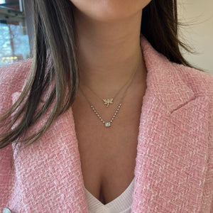 Female Model Wearing Emerald-Cut Diamond Illusion Pendant on Diamond Chain - 14K gold weighing 3.0 grams - 24 round diamonds weighing 0.48 carats - 6 straight baguettes weighing 0.20 carats