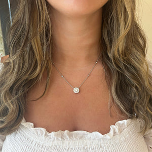 Female Model Wearing 1.65 ct Halo Diamond Pendant with Diamond Chain - 18K gold weighing 4.95 grams - 15 round diamonds weighing 0.64 carats - 1.01 ct round diamond (GIA-graded H-color, I1 clarity). Stone has been enhanced for clarity.