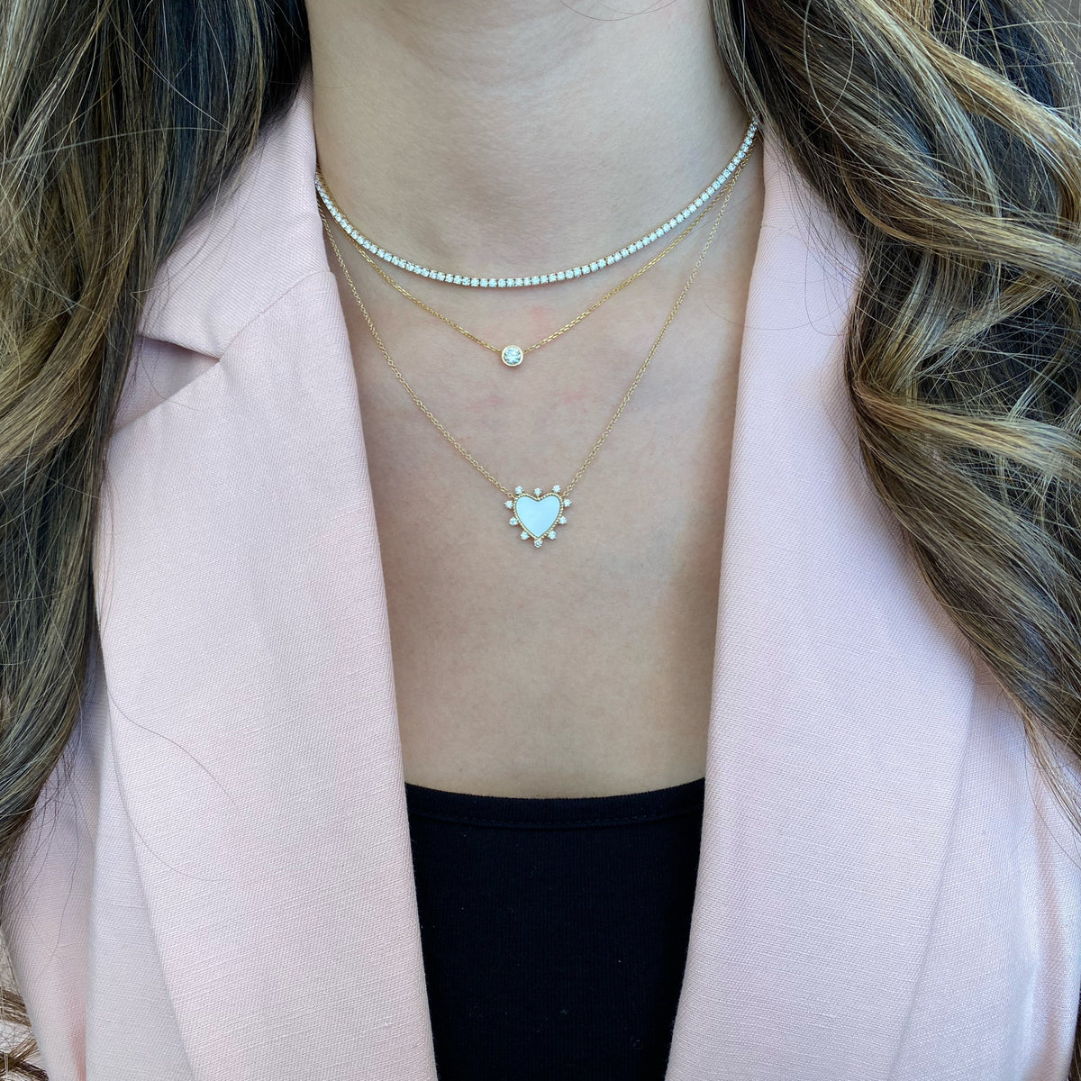 Female Model Wearing Diamond & Mother of Pearl Heart Pendant Necklace - 14K gold weighing 2.61 grams - 10 round diamonds weighing 0.26 carats - Mother of Pearl