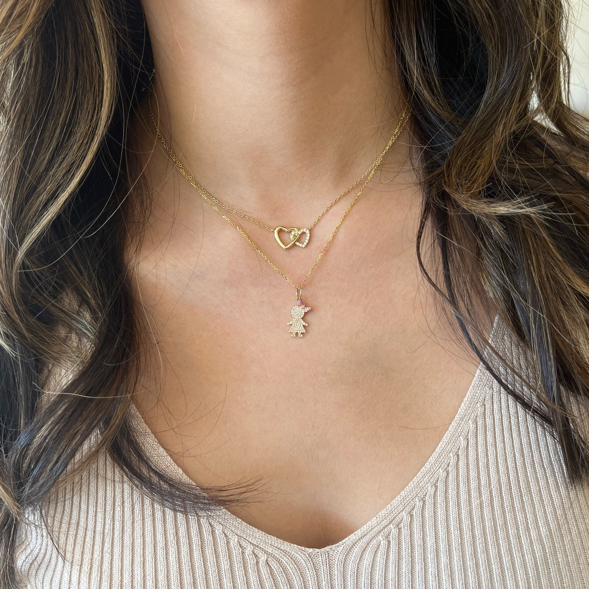 Female Model Wearing Diamond & Pink Sapphire Girl Pendant - 14K gold weighing 1.66 grams  - 88 round diamonds weighing 0.16 carats  - 19 pink sapphires weighing 0.06 carats