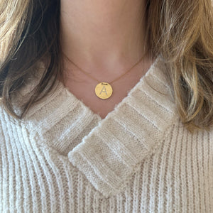 Female model wearing Gold & Diamond Initial Disc Pendant -14K gold weighing 6.97 grams -25 round diamonds totaling 0.07 carats 16-18” adjustable chain