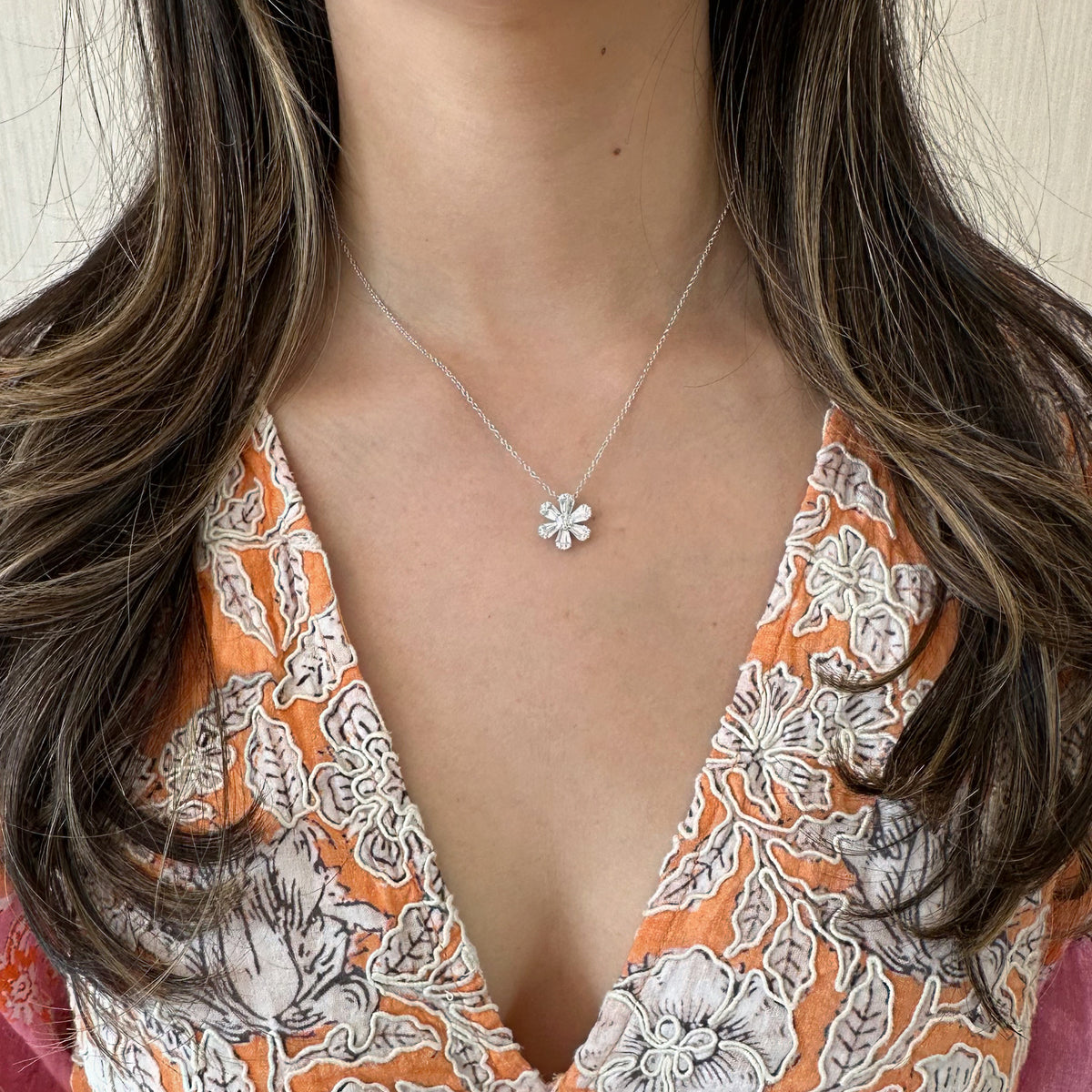 Female Model Wearing Round and Baguette Diamond Flower Pendant - 18K gold weighing 4.07 grams - 25 round diamonds weighing 0.13 carats - 12 slim baguettes weighing 0.64 carats
