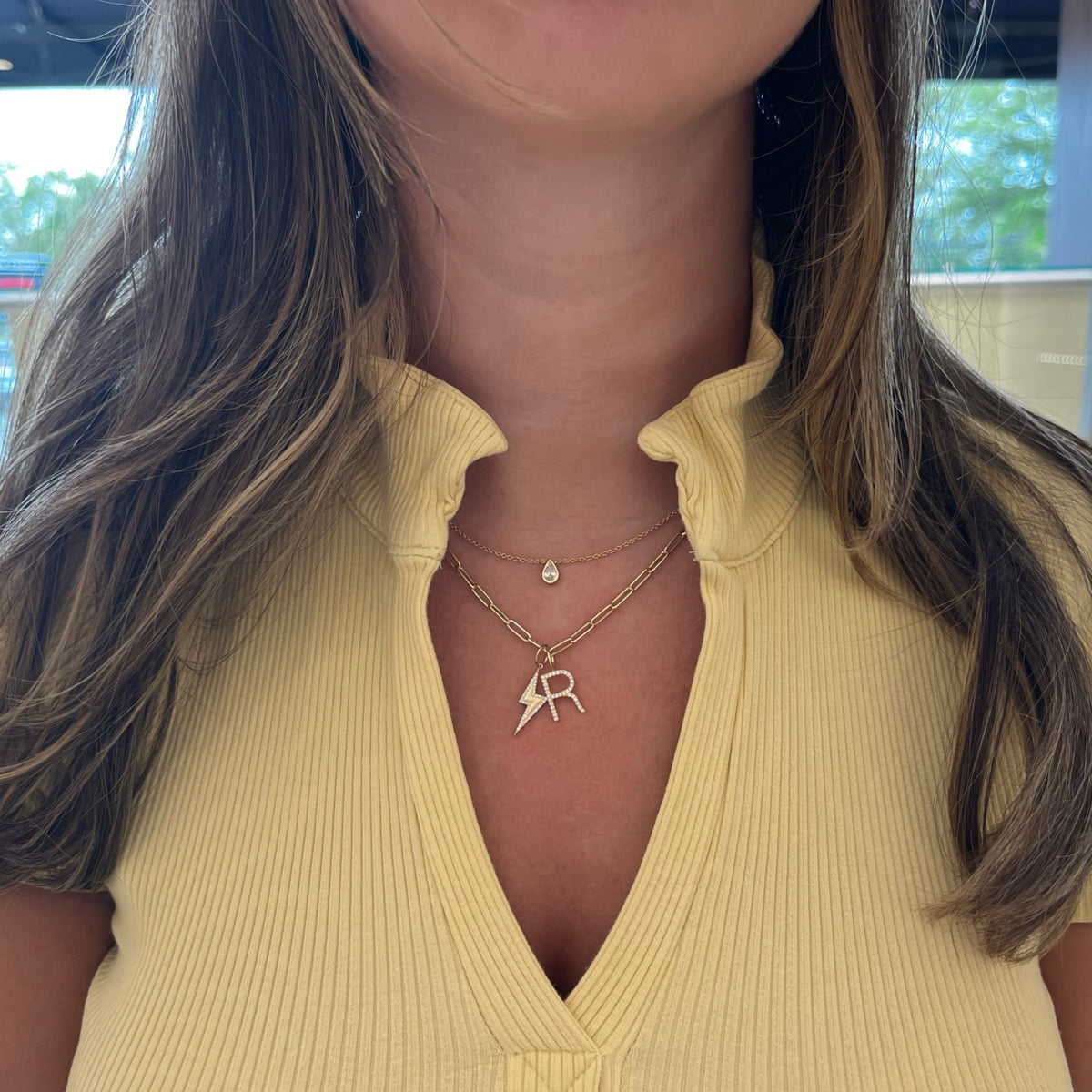 Female Model Wearing Diamond Initial Pendant - 14K gold weighing 0.59 grams - 29 round diamonds totaling 0.08 carats