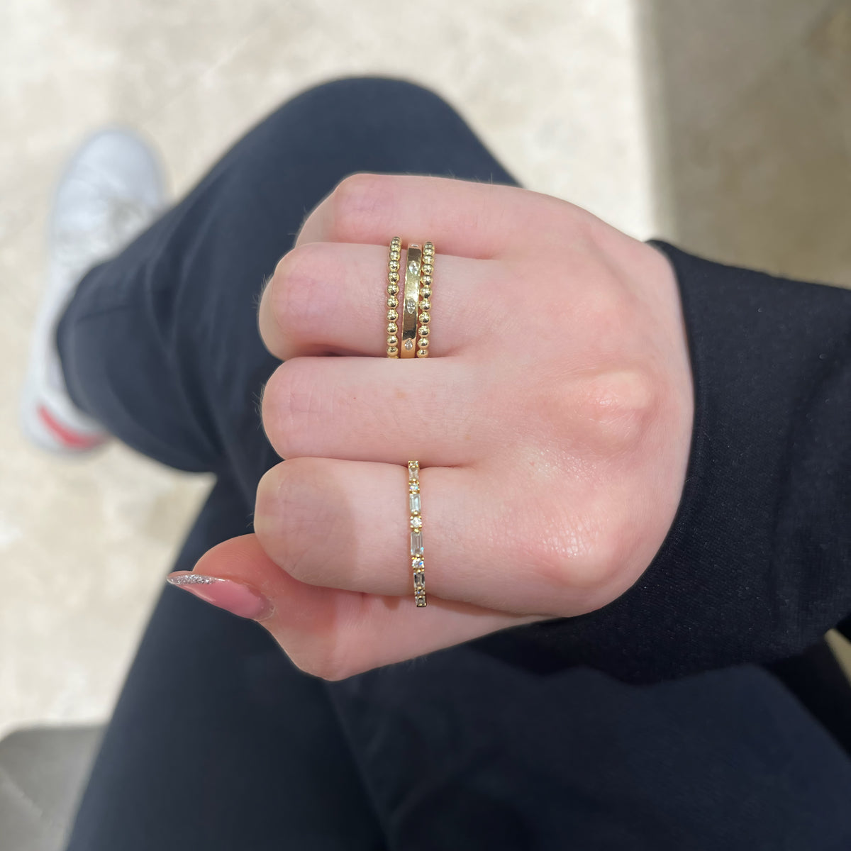 Female Model Wearing Round & Baguette Diamond Stackable Ring - 18K gold weighing 1.43 grams - 6 round diamonds weighing 0.05 carats - 5 baguette diamonds weighing 0.16 carats
