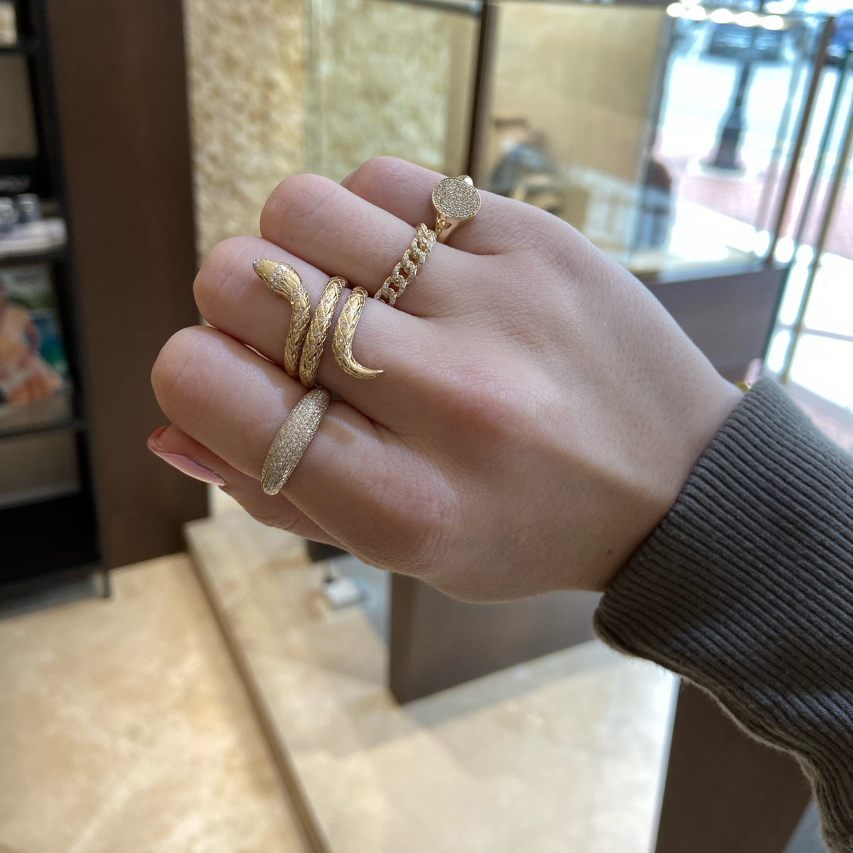 Female Model Wearing Diamond & Emerald Serpent Ring - 14K gold weighing 5.92 grams - 95 round diamonds weighing 0.28 carats - 2 emeralds weighing 0.01 carats