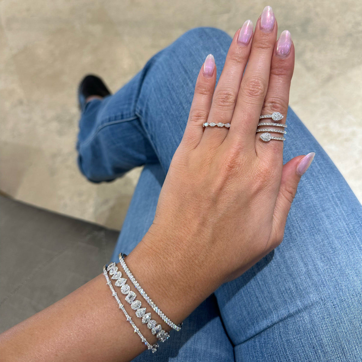 Female Model Wearing Mixed Shape Halo Diamond Bangle Bracelet - 14K gold weighing 13.30 gram - 15 mixed shape diamonds weighing 1.63 carats - 192 round diamonds weighing 0.88 carats