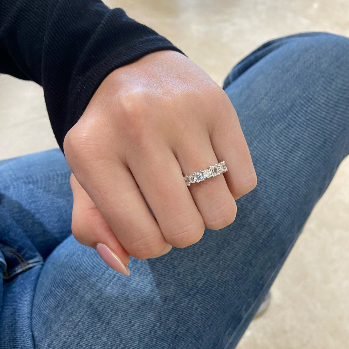 Female Model Wearing Emerald-Cut & Round Diamond Wedding Band - 18K gold weighing 3.53 grams - 4 round diamonds weighing 0.74 carats - 5 emerald-cut diamonds weighing 0.97 carats