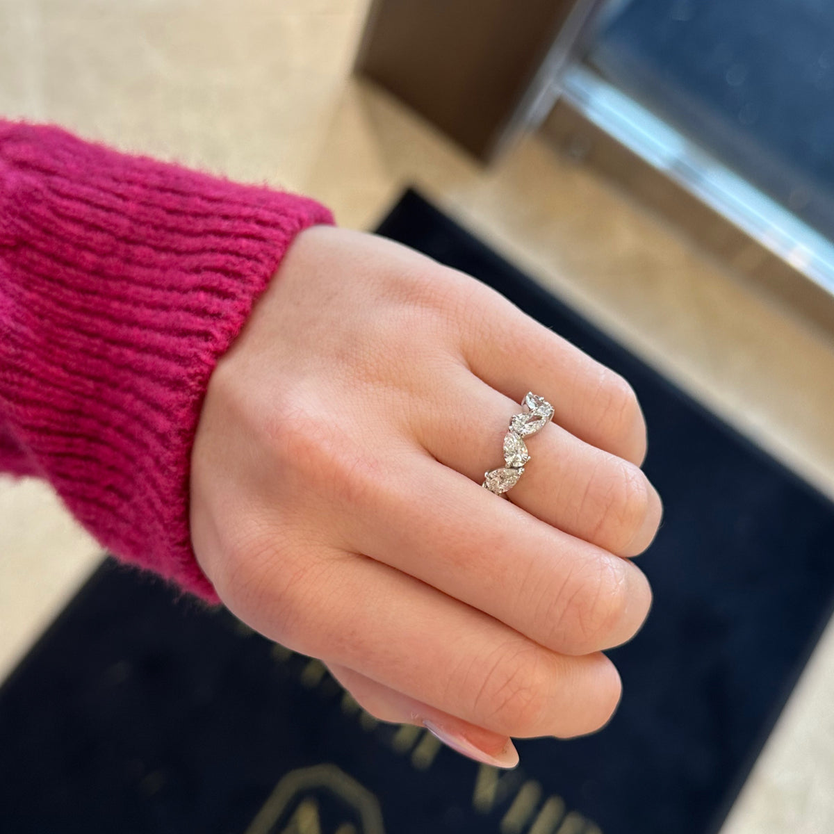 Female model wearing Pear-Shaped Diamond Eternity Band - 18K gold weighing 4.75 grams - 12 pear-shaped diamonds totaling 4.63 carats