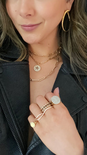 Female Model wearing Wavy Double-finger Diamond Ring  -18k gold 5.82 grams  -57 round shared prong-set diamonds .58 carats.