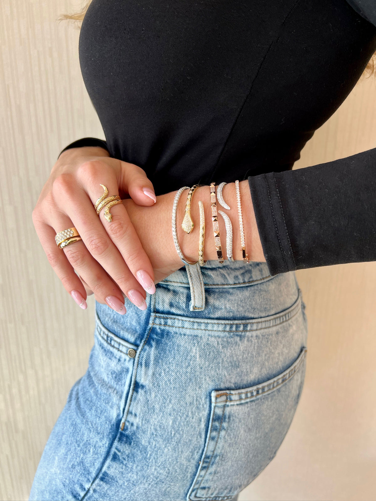 Female model wearing Diamond Medium Classic Bangle Bracelet -18K gold weighing 12.42 grams - 27 round diamonds totaling 1.53 carats