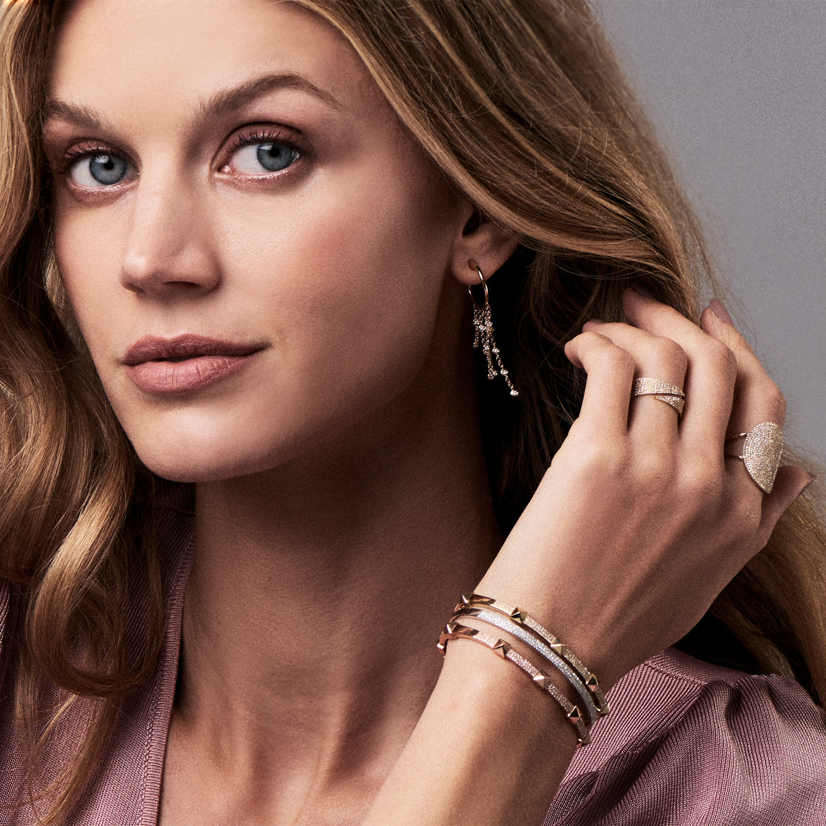 Female model wearing Gold hoop earrings with bezel set diamond drops - 14K gold weighing 4.60 grams   - 28 round stones with 0.28 total carat weight