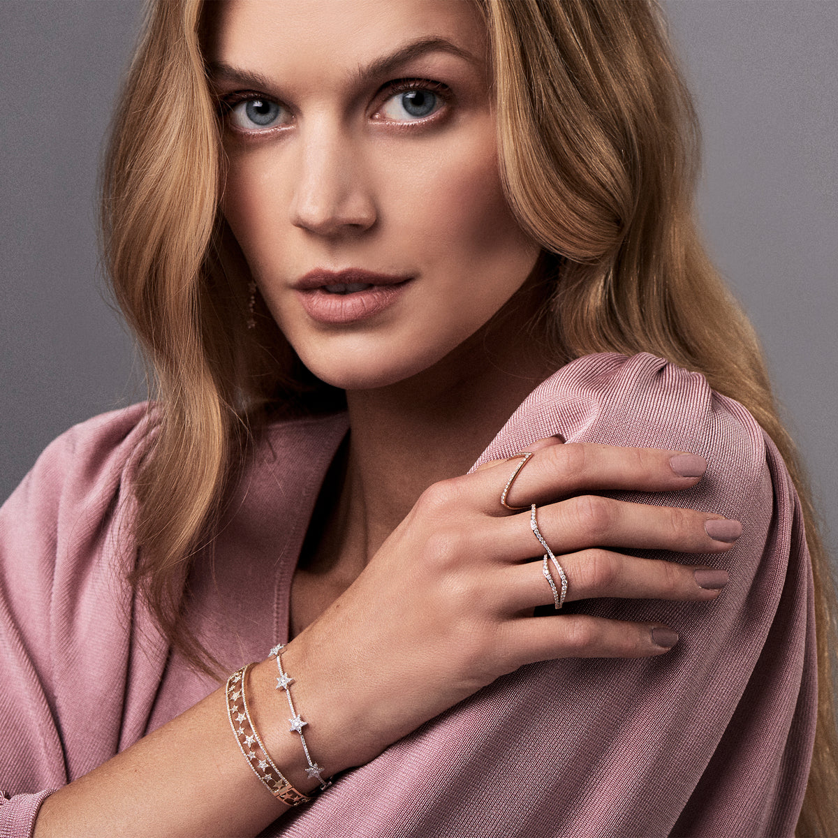 Female model wearing Diamond Stars Bracelet - 14K gold weighing 5.85 grams - 236 round shared prong-set diamonds totaling 0.86 carats. -7 round diamonds totaling .21 carats