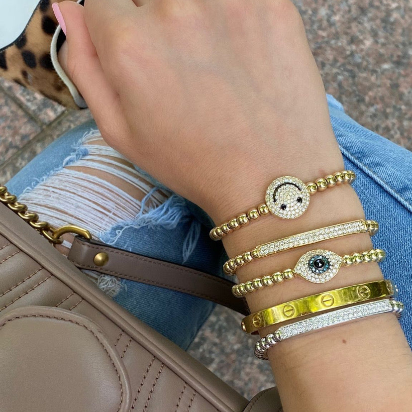 Diamond Smiley Face Bracelet - 14K yellow gold weighing 16.20 grams - 92 round diamonds totaling 0.96 carats - 2 black round diamonds totaling 0.05 carats