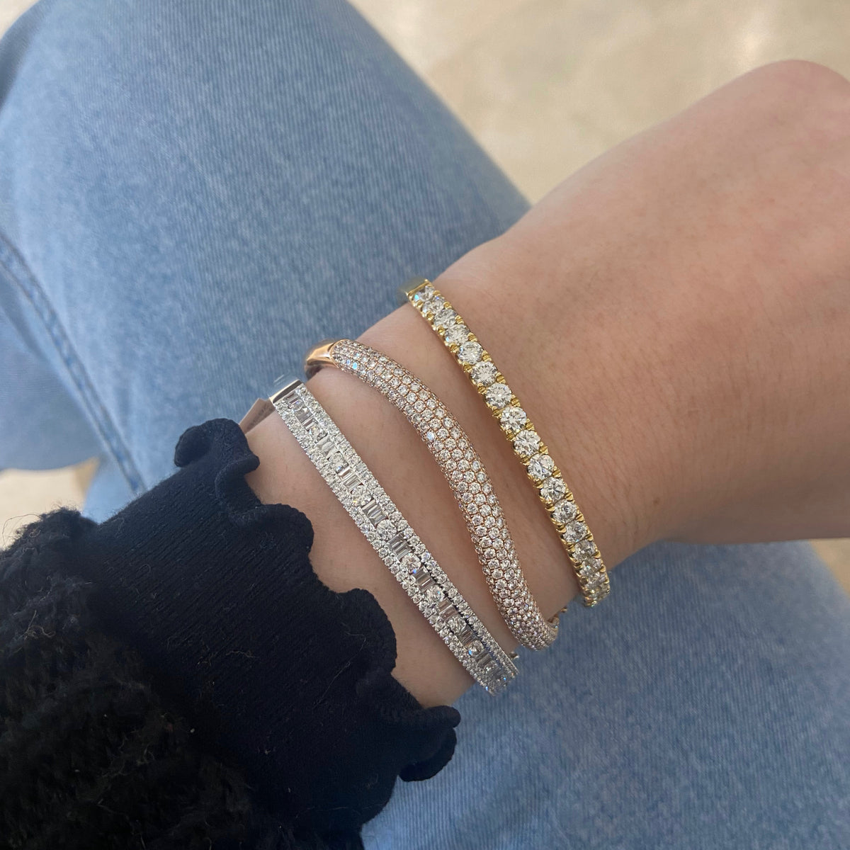 Female model wearing Round & Baguette Diamond Bangle - 14K gold weighing 13.12 grams - 143 round diamonds totaling 1.92 carats - 24 straight baguettes weighing 0.73 carats