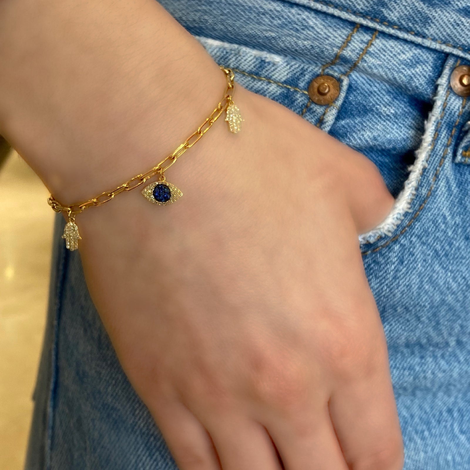 Diamond & Sapphire Evil-Eye & Hamsa Charm Bracelet -14K gold weighing 5.86 grams -138 round diamonds totaling 0.32 carats -9 sapphires totaling 0.20 carats